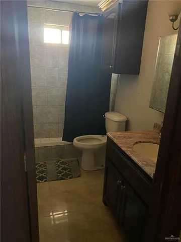 a bathroom with a granite countertop toilet and a sink