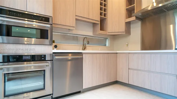 a kitchen with stainless steel appliances white cabinets and a wooden floor