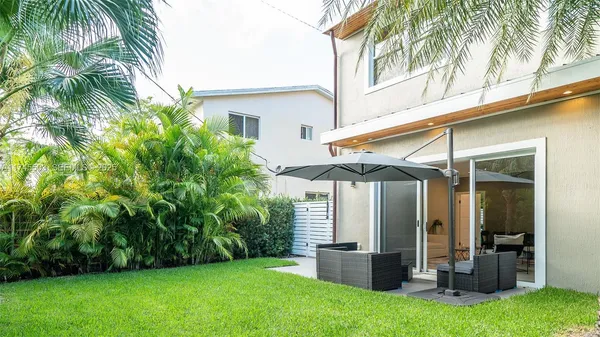 a view of a chair and table in backyard of the house