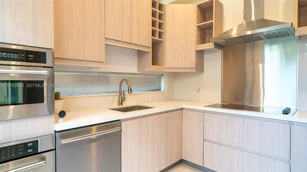a kitchen with stainless steel appliances granite countertop a sink and a white cabinets