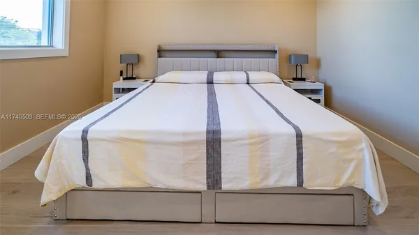 a bed sitting in a bedroom next to a window