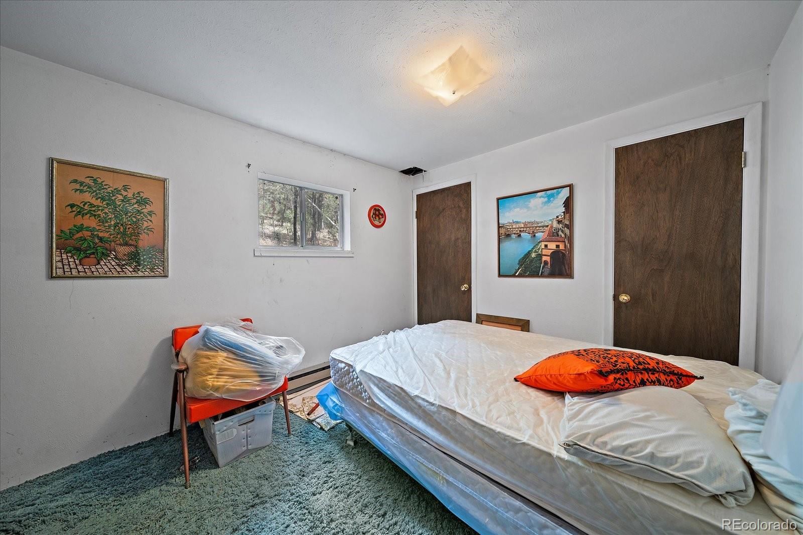 118 Neish Street Bailey, CO 80421 - Photo 14 of 27 a bedroom with a bed and a dresser in it