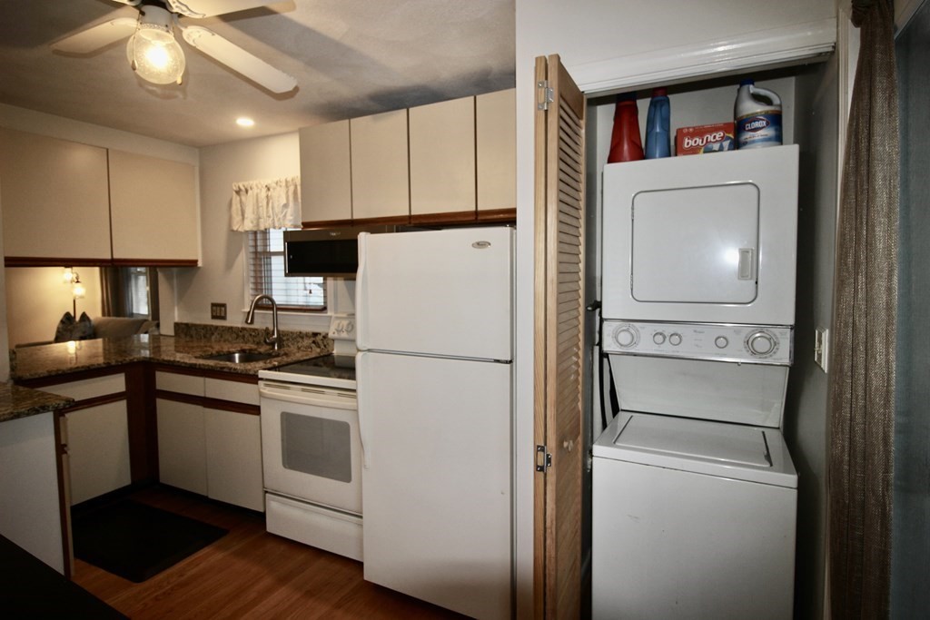 133 Hardy Pond Road Waltham, MA 02451 - Photo 17 of 30 a kitchen with a refrigerator a stove cabinets and wooden floor