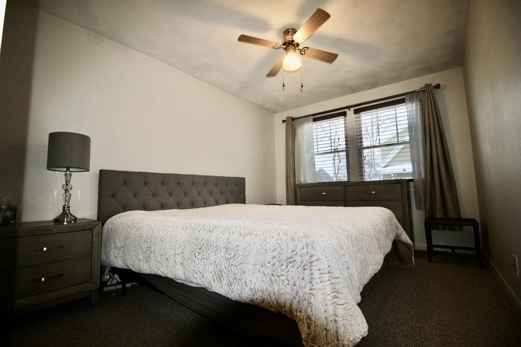 133 Hardy Pond Road Waltham, MA 02451 - Photo 18 of 30 a bedroom with a bed and a chandelier