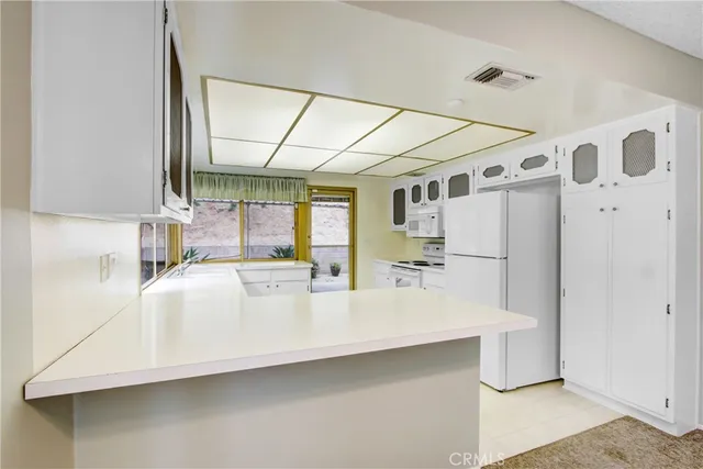 a large white kitchen with a large window