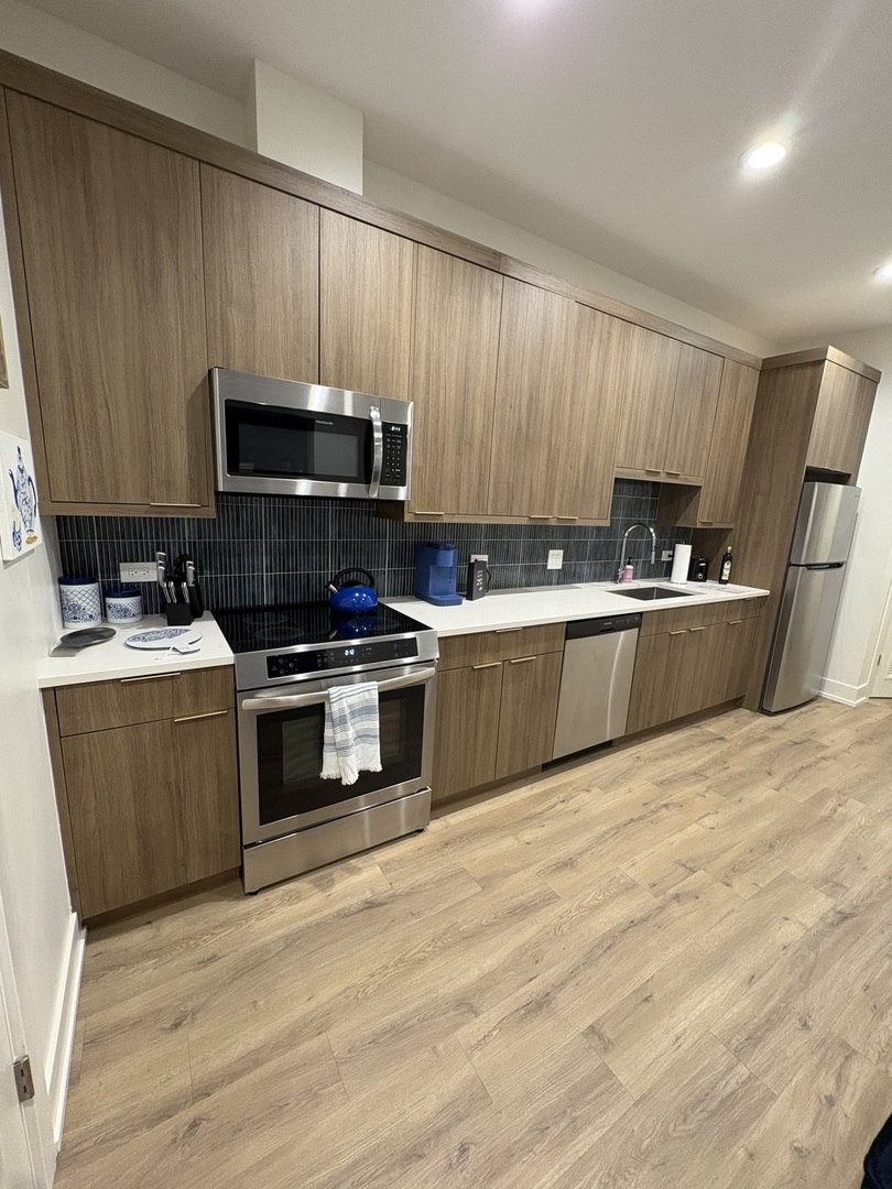 6317 South Rhodes Avenue, Unit G Chicago, IL 60637 - Photo 4 of 14 a kitchen with granite countertop a sink a stove top oven and cabinetry