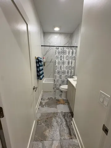a bathroom with a toilet and a shower