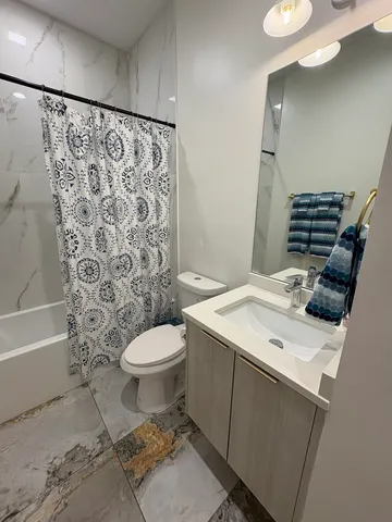 a bathroom with a sink toilet and shower