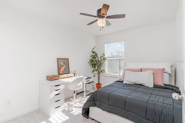 a bedroom with a bed a chandelier and a dresser