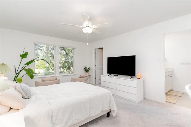 a bedroom with a bed a flat tv and a couch