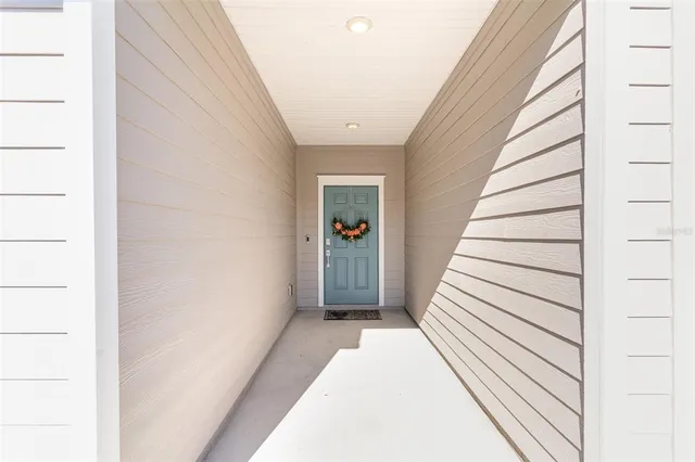a view of a hallway with wooden floor and entryway