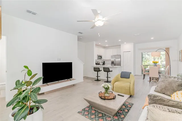a living room with furniture a chandelier and a flat screen tv