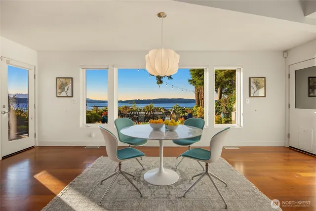 a dining room with wooden floor and a chandelier