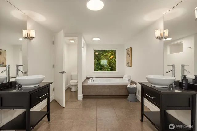 a bathroom with a granite countertop sink and a bathtub