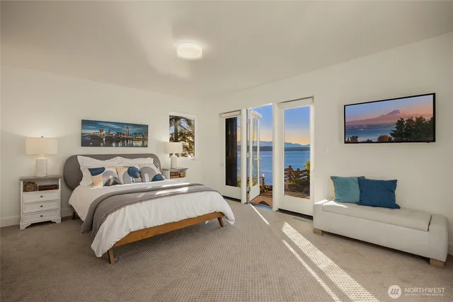 a bedroom with a bed couch and a large window