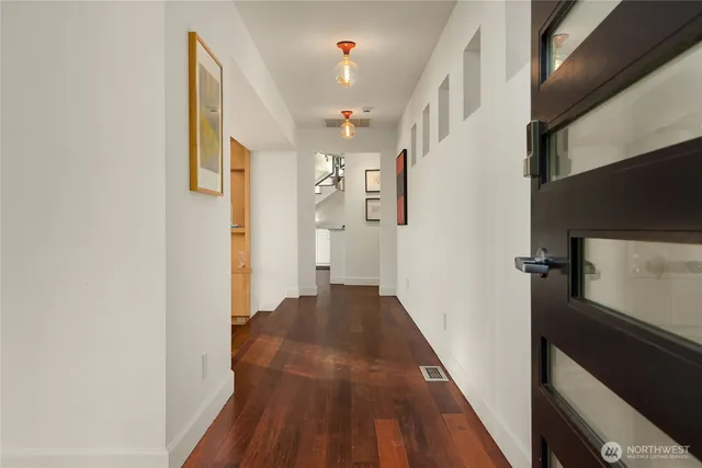 a view of a hallway with wooden floor and staircase
