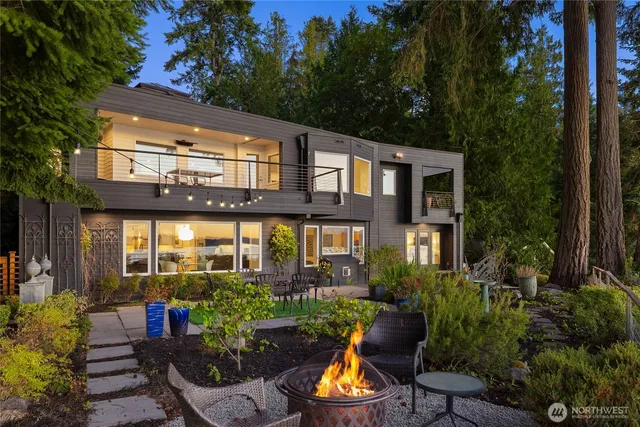 a view of a patio with couches chairs potted plants and a large tree