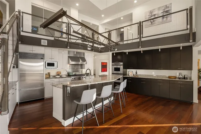 a kitchen with stainless steel appliances granite countertop a sink and a refrigerator