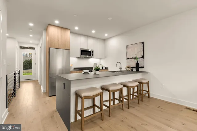a kitchen with kitchen island granite countertop a sink and refrigerator
