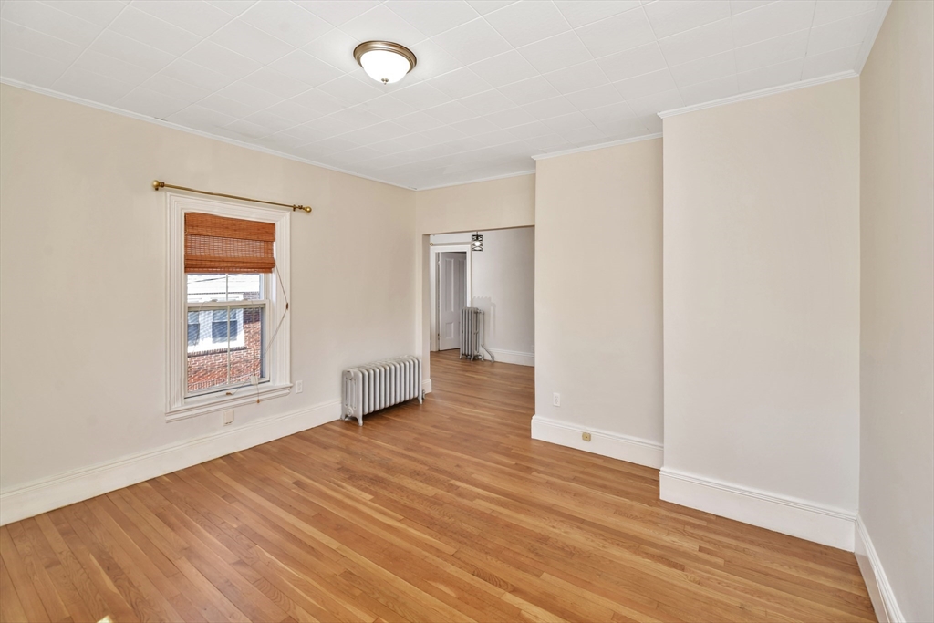 492 Metropolitan Avenue, Unit 2 Boston, MA 02136 - Photo 4 of 15 a view of an empty room with wooden floor and a window