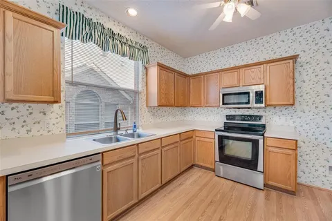 a kitchen with stainless steel appliances granite countertop a sink a stove top oven and cabinetry