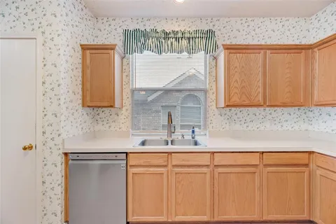 a large kitchen with a sink and wooden floor