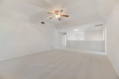 a view of an empty room with a chandelier fan
