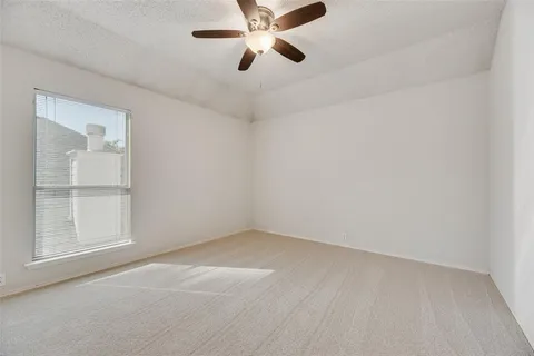 a view of an empty room with a chandelier fan