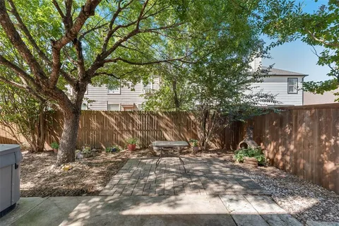 a backyard of a house with barbeque oven and trees