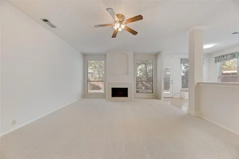 an empty room with windows and a fireplace