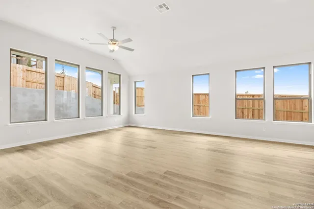 a view of an empty room with glass door and balcony
