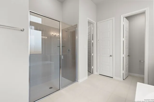 a bathroom with a shower and a glass door