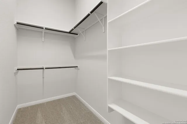 a view of walk in closet with empty racks