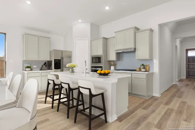 a kitchen with a table chairs refrigerator and cabinets