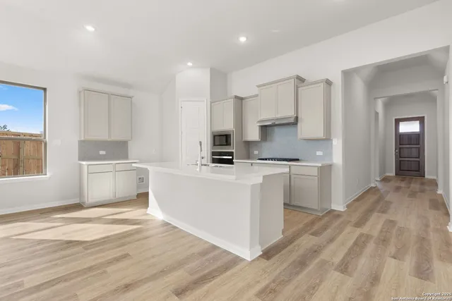 a kitchen with white cabinets and white appliances