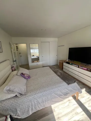 a bedroom with a bed and a flat screen tv