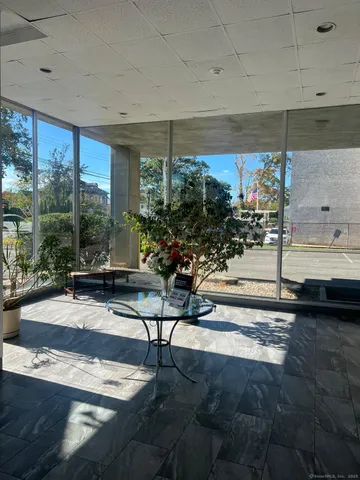 a living room with patio furniture and a floor to ceiling window