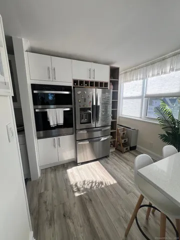 a kitchen with granite countertop a refrigerator and wooden floor