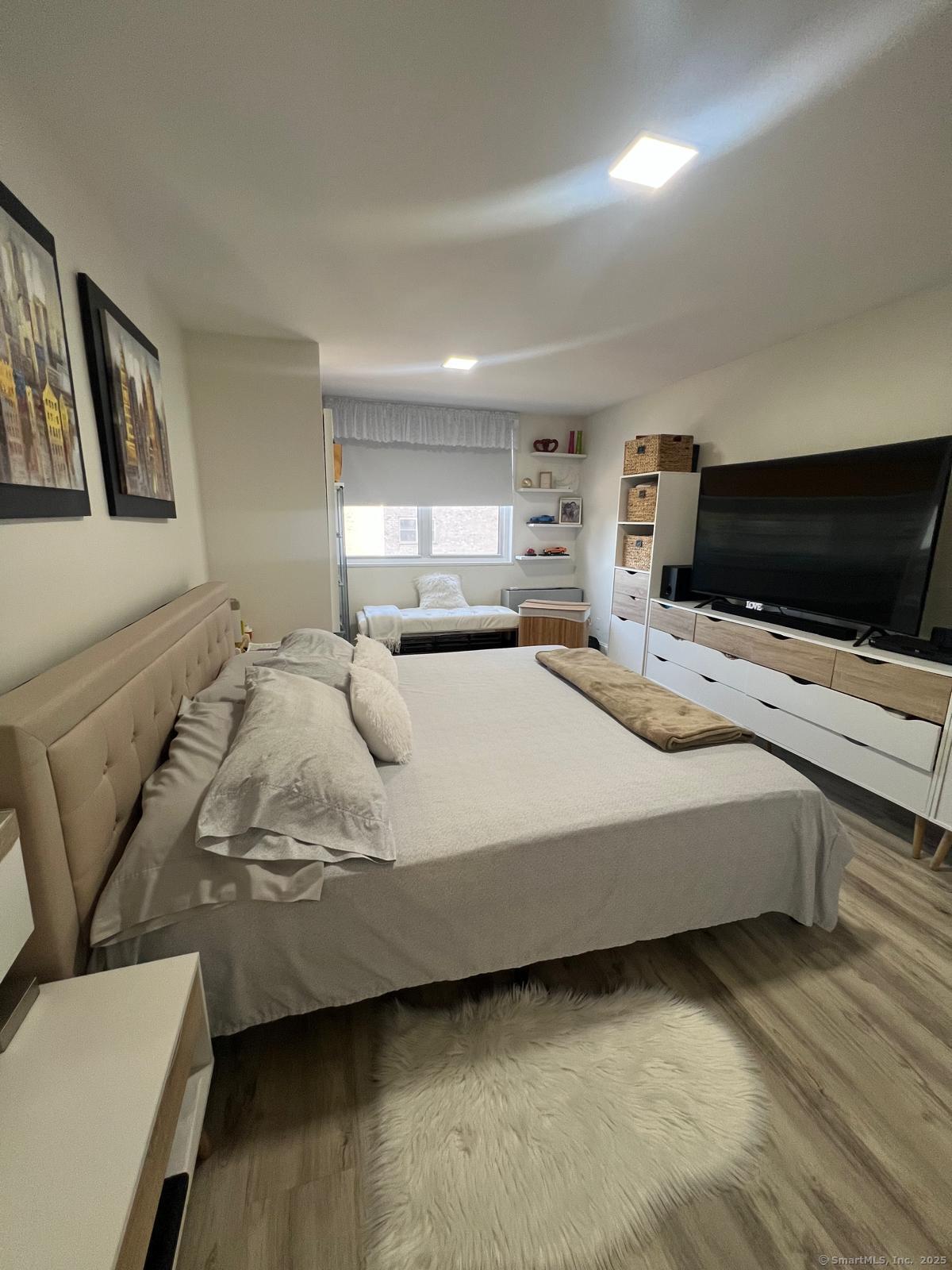 2370 North Avenue, Unit 3F Bridgeport, CT 06604 - Photo 9 of 25 a large bedroom with a bed and flat screen tv