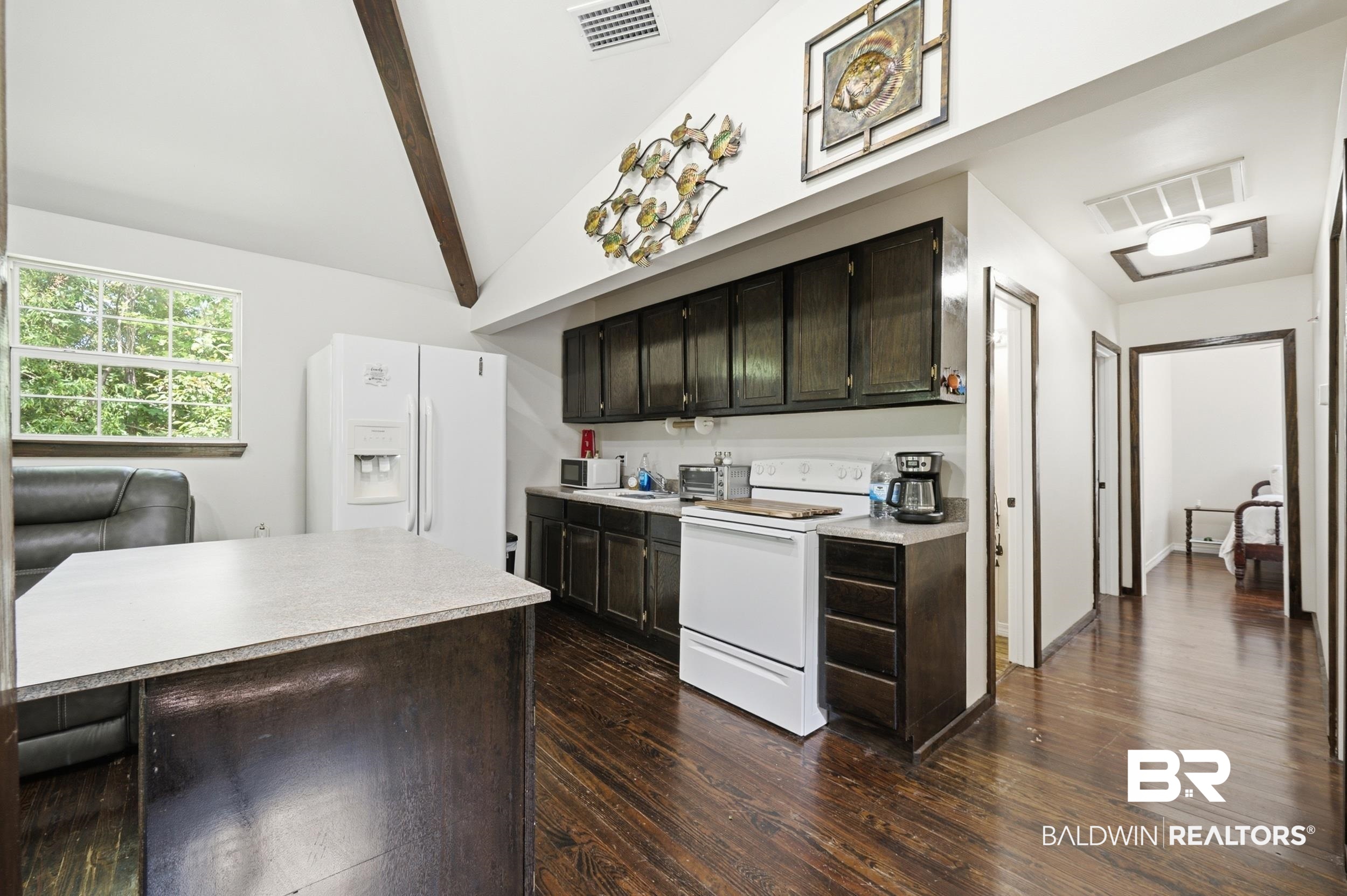 42080 Bayou Road Bay Minette, AL 36507 - Photo 13 of 43 Kitchen featuring dark wood-finish cabinetry, light-toned countertops, and wood-finish flooring