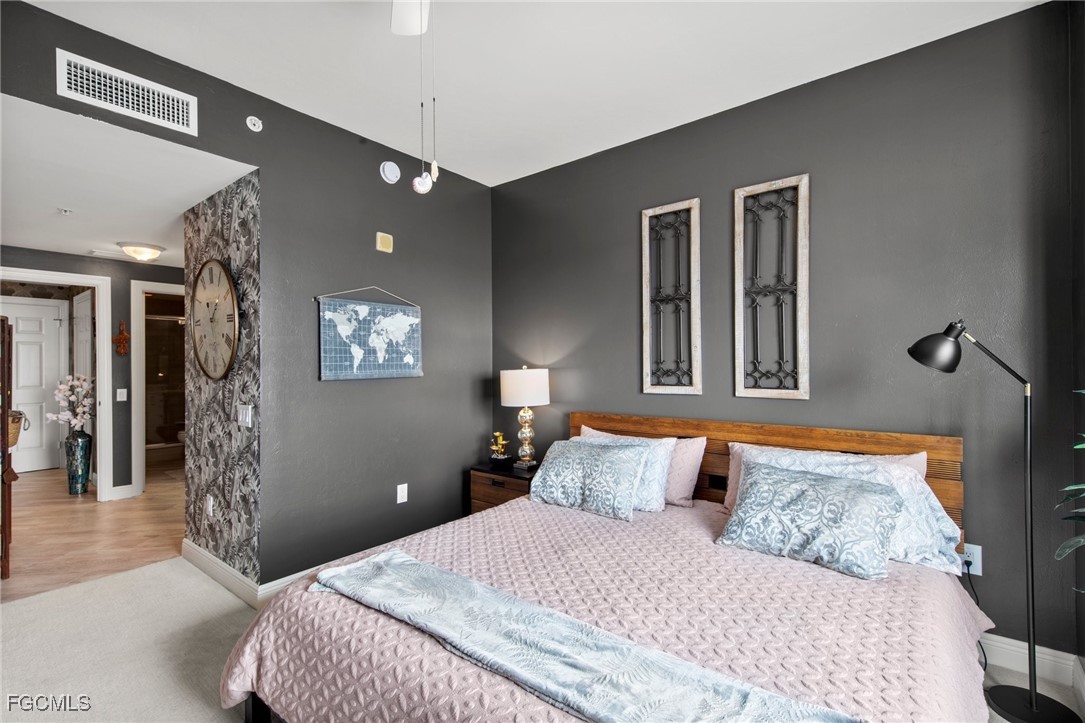 2745 First Street, Unit 1602 Fort Myers, FL 33916 - Photo 30 of 49 a bedroom with a large bed and a chandelier