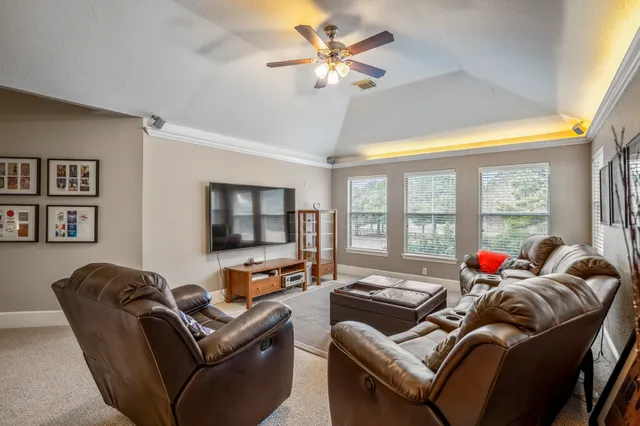 a living room with furniture ceiling fan and a window