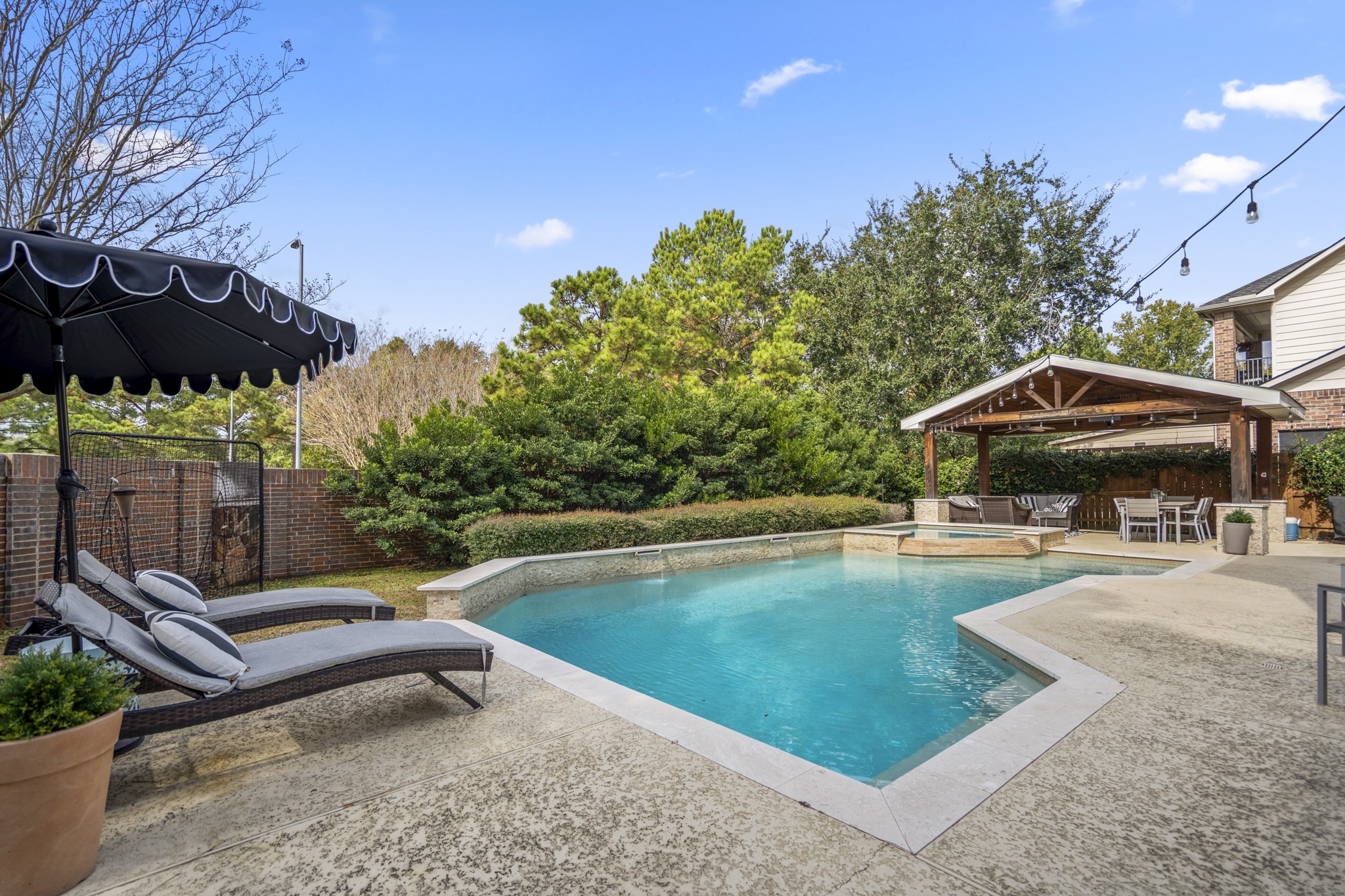 10203 Earlington Manor Drive Spring, TX 77379 - Photo 30 of 50 a view of pool with lawn chairs under an umbrella