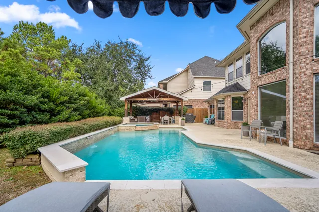 a view of a house with pool and chairs
