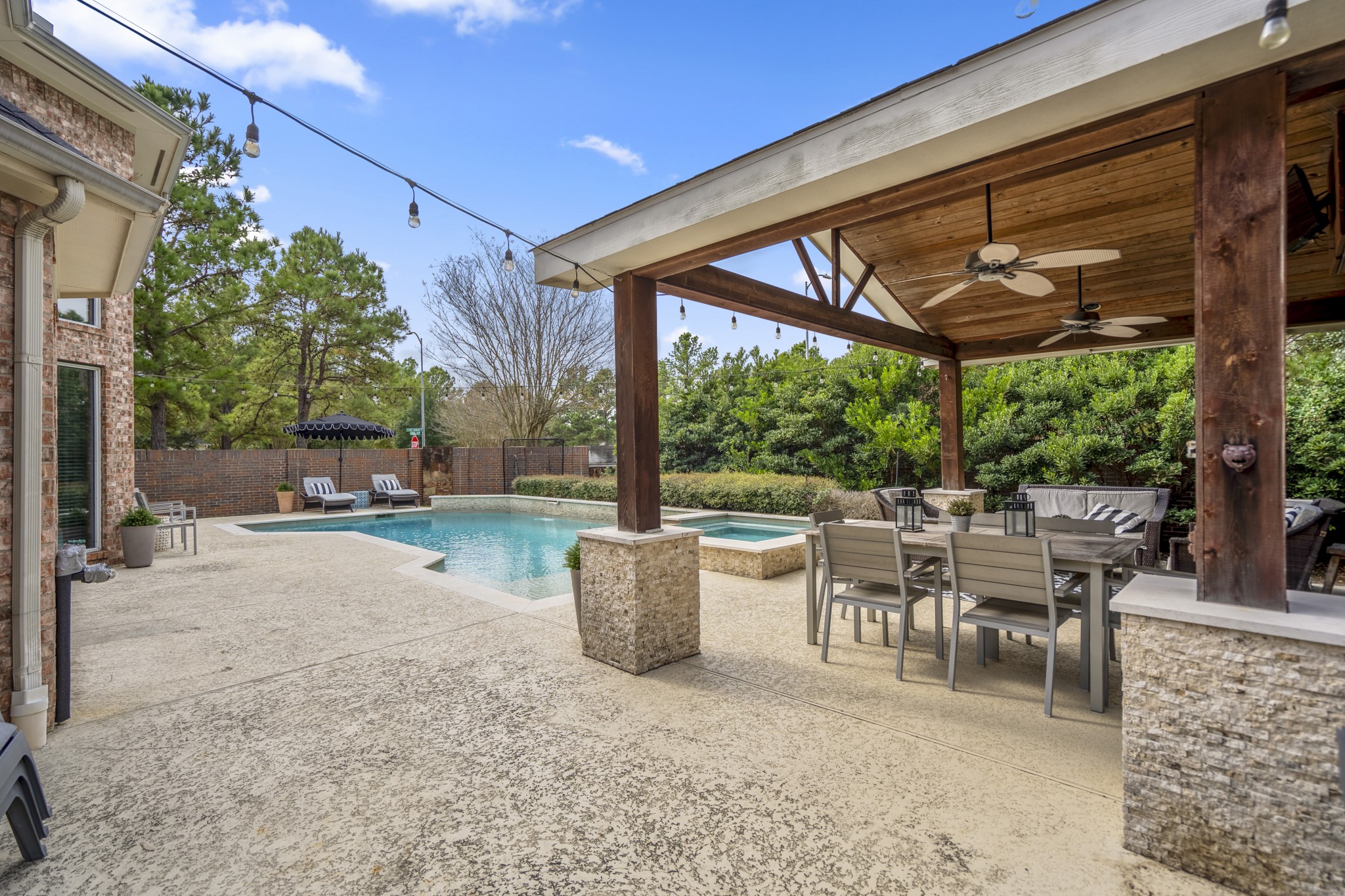 10203 Earlington Manor Drive Spring, TX 77379 - Photo 32 of 50 a view of a patio with table and chairs potted plants and floor to ceiling window