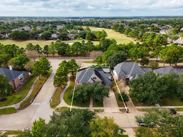 an aerial view of residential houses with outdoor space and swimming pool