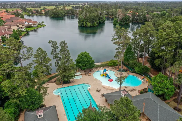 an aerial view of lake residential house with outdoor space and trees around