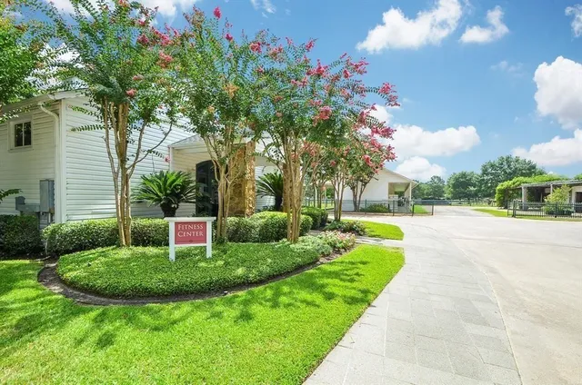 a view of a house with a big yard plants and large trees