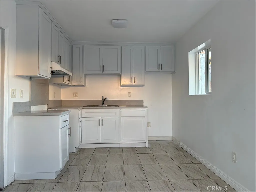4118 East San Vincente Street Compton, CA 90220 - Photo 3 of 15 a kitchen with granite countertop white cabinets stainless steel appliances and a sink