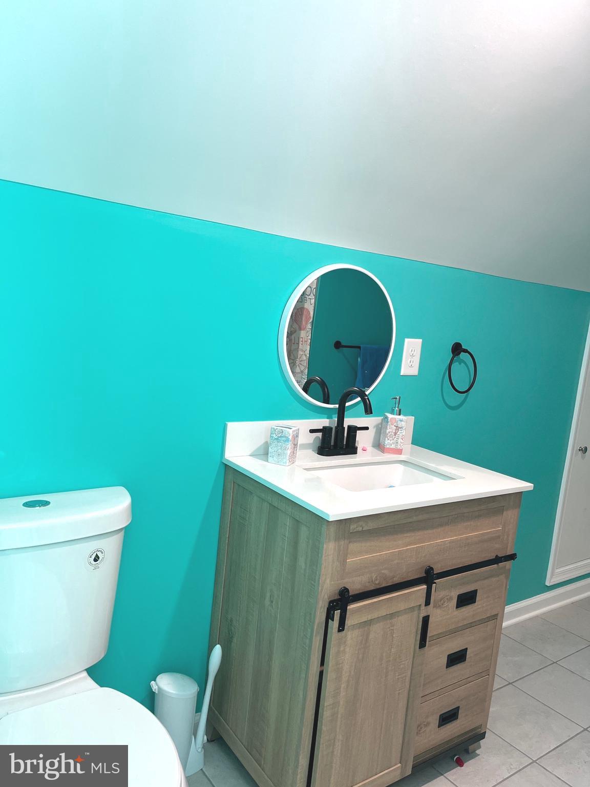 113 West Edgevale Road Baltimore, MD 21225 - Photo 26 of 41 a bathroom with a toilet a sink and mirror